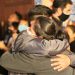 two people hugging each other in front of a crowd of people